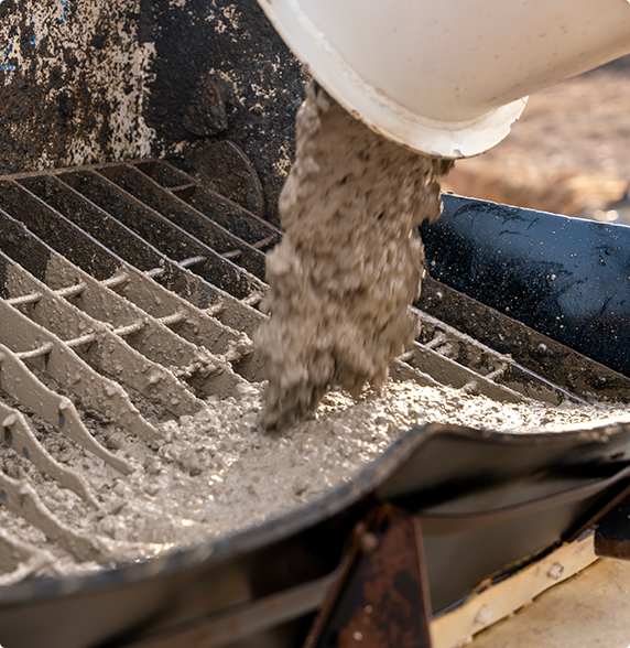 A person is pouring concrete into a bucket.