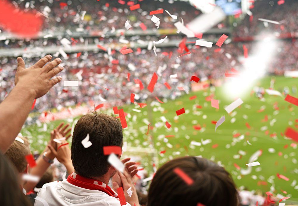 fans in stadium with confetti falling