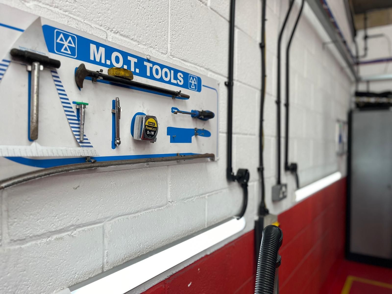 A wall with a sign that says m.o.t. tools