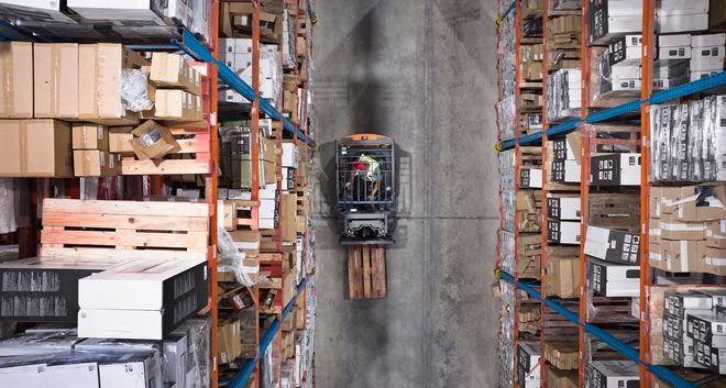 Young warehouse worker sitting in forklift Young warehouse worker sitting in forklift