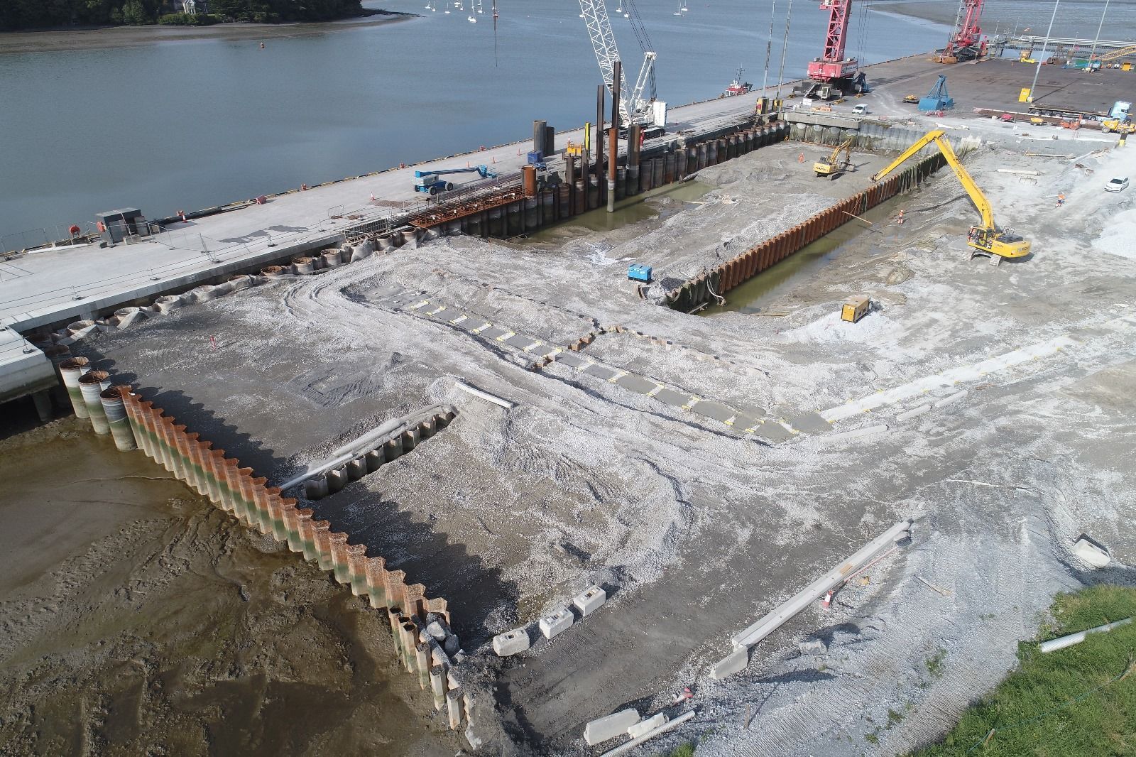An aerial view of a construction site next to a body of water