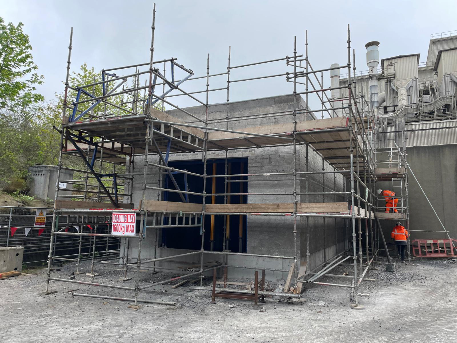A construction site with scaffolding and a sign that says bbc 310