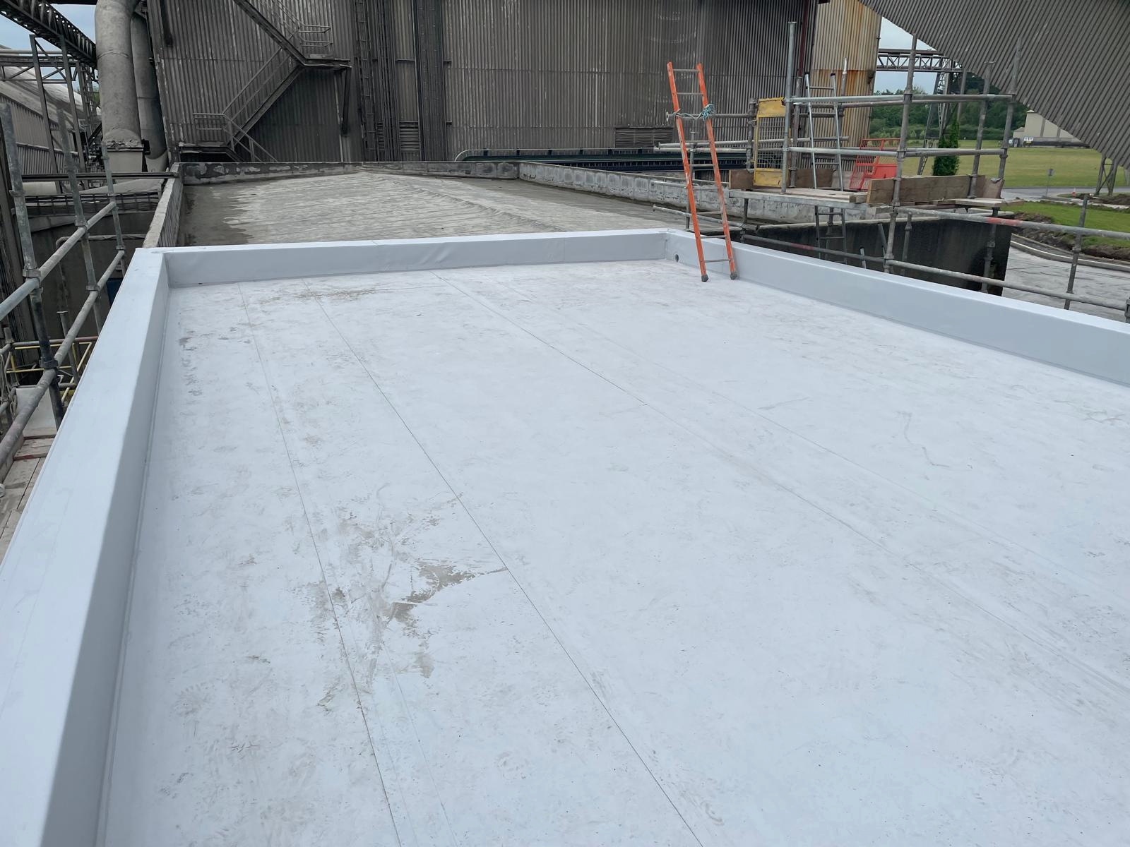 A large white concrete surface with a scaffolding in the background