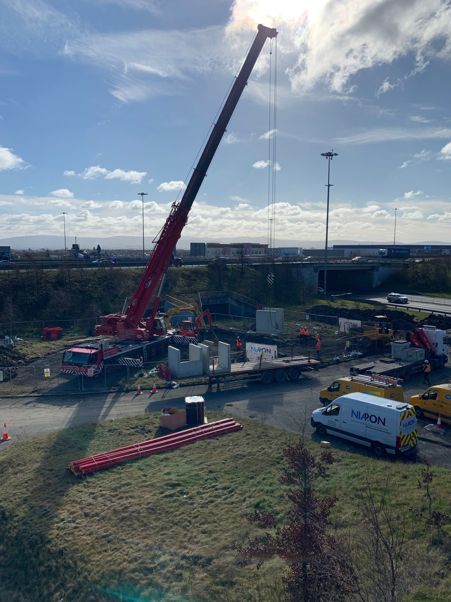 An aerial view of a construction site with a large red crane
