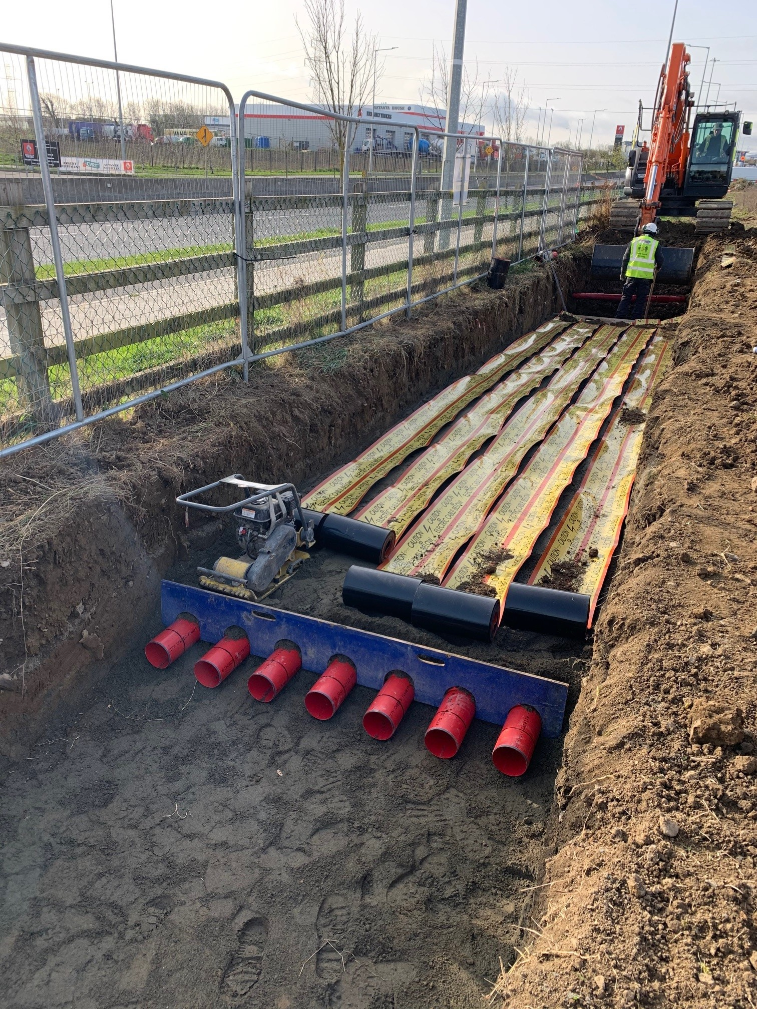 A man in a yellow vest is working on a construction site.