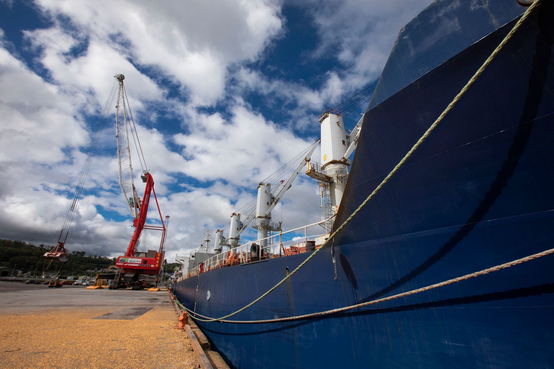 A large blue ship is docked in a harbor
