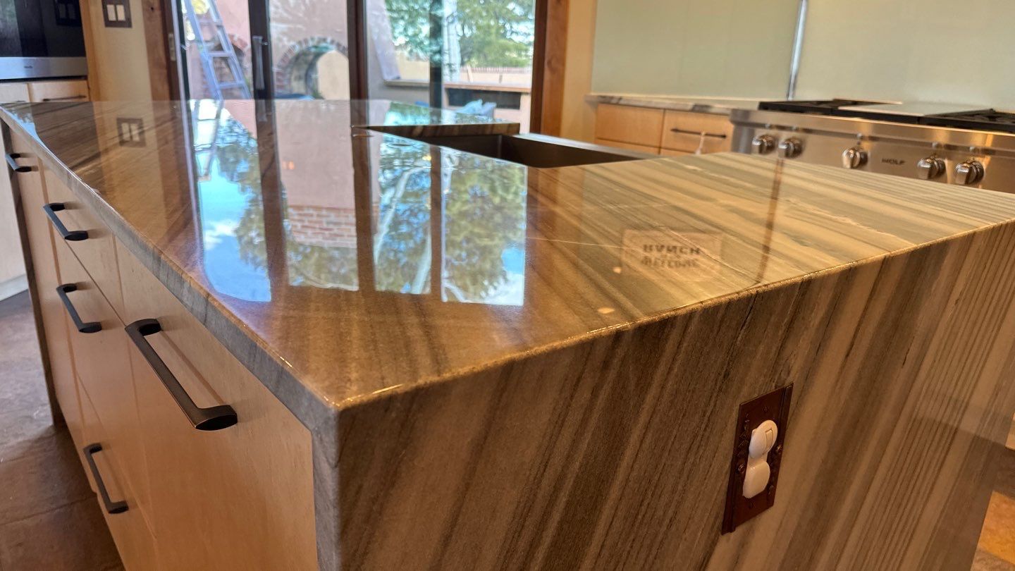 A kitchen sink is sitting on top of a granite counter top.