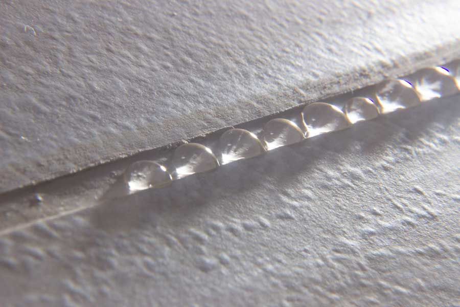 A close up of a piece of paper with water drops on it