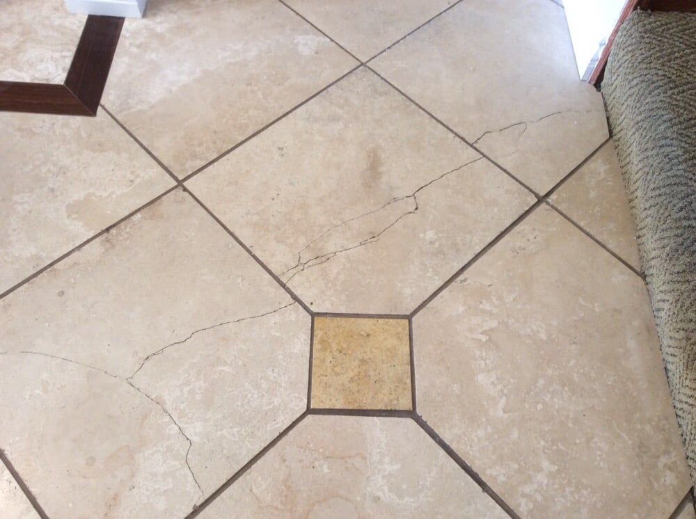 A cracked tile floor with a square in the middle