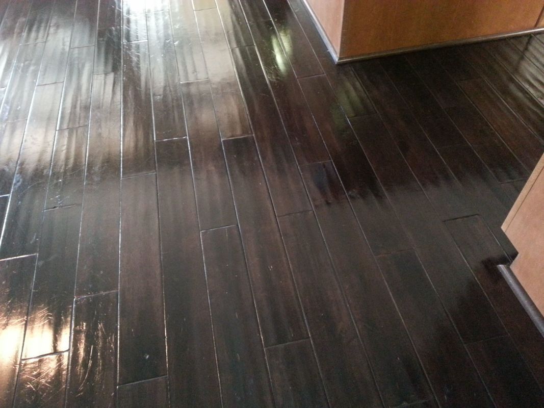 A close up of a dark wooden floor in a kitchen