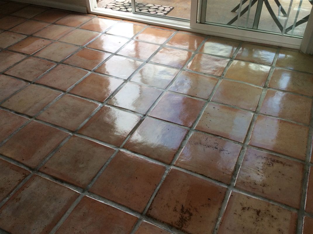 A tiled floor with a sliding glass door in the background.