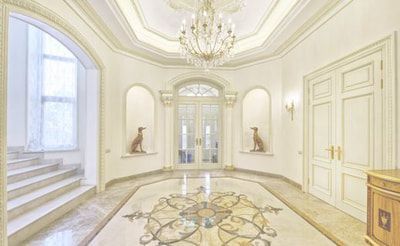 A large hallway with a marble floor and a chandelier.