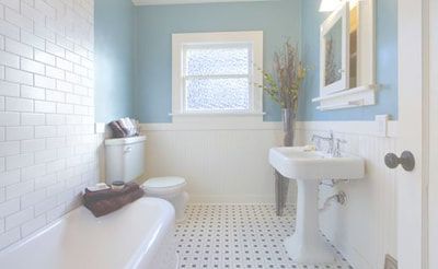 A bathroom with a bathtub , sink , toilet and window.