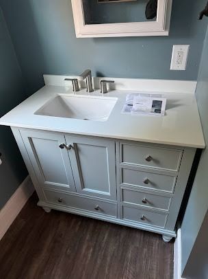 A bathroom vanity with a sink and a mirror.