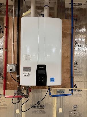 A white water heater is hanging on a wall in a room.