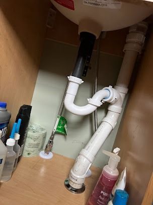 A bathroom sink with a drain pipe underneath it.