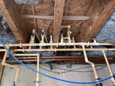 A bunch of pipes are hanging from the ceiling of a building.