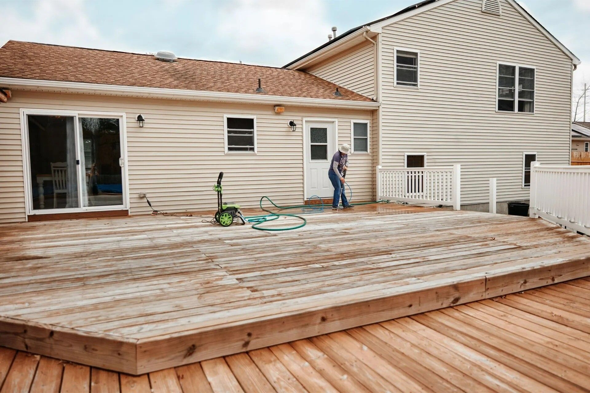 A man is standing on a wooden deck in front of a house. - Corpus Christi, TX - Republic of Texas Foundation Repair