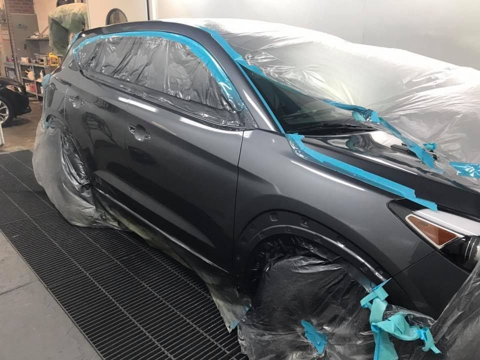 A car is being painted in a paint booth.