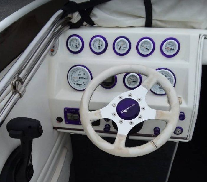 A white boat with a purple steering wheel