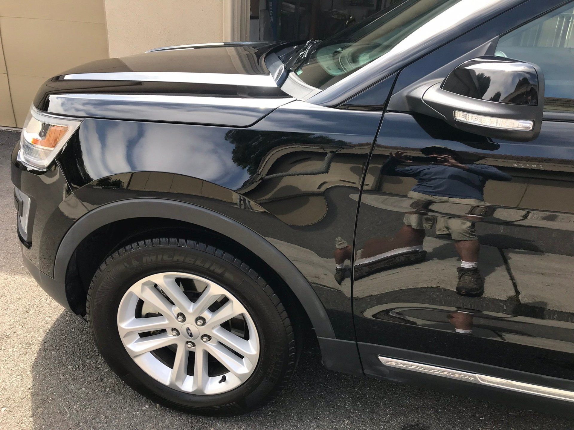 A black ford explorer is parked in front of a garage.