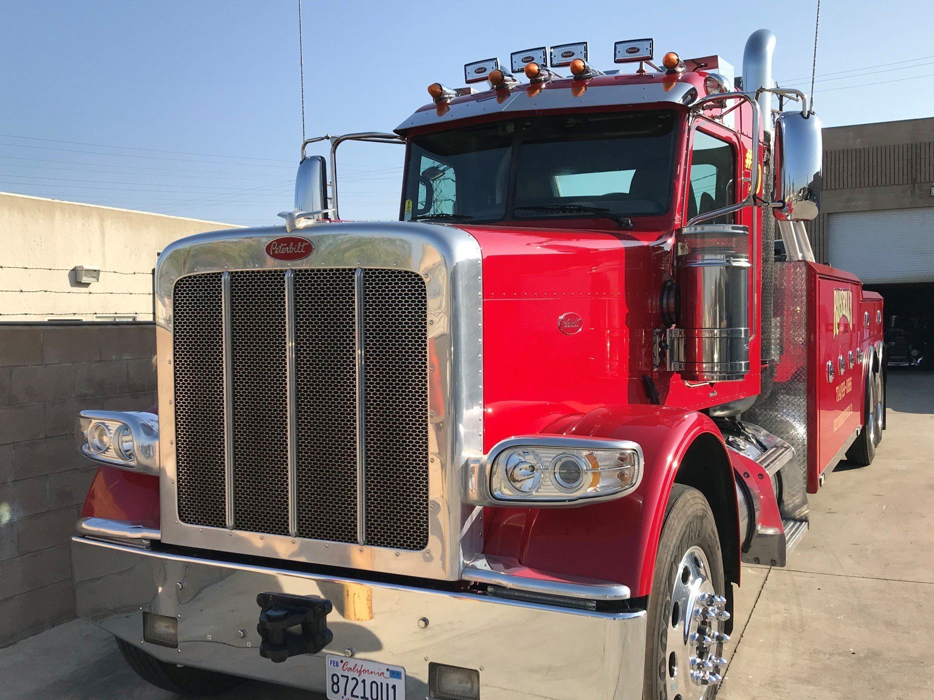 A red tow truck is parked in front of a building.