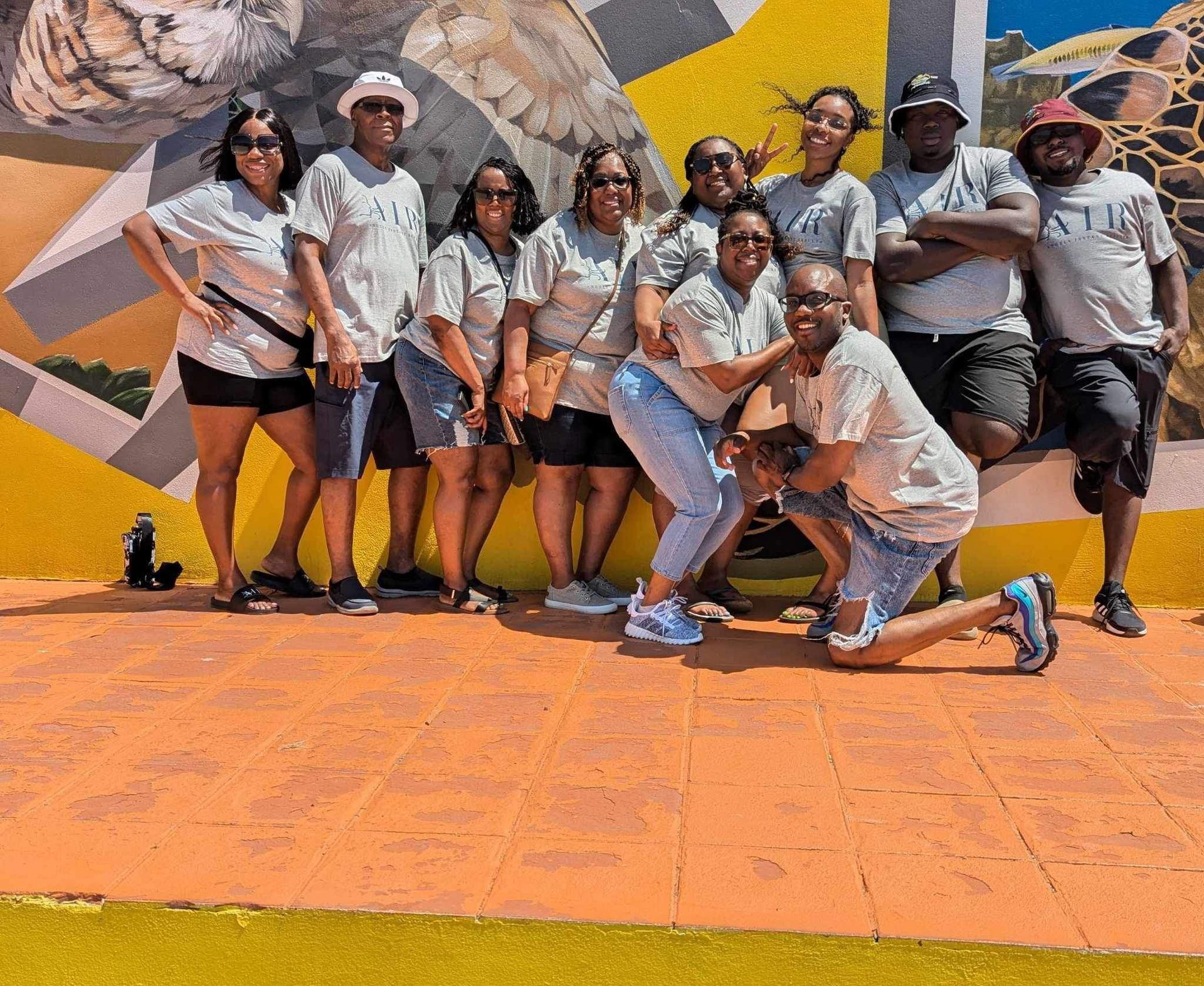 A group of people are posing for a picture in front of a yellow wall.