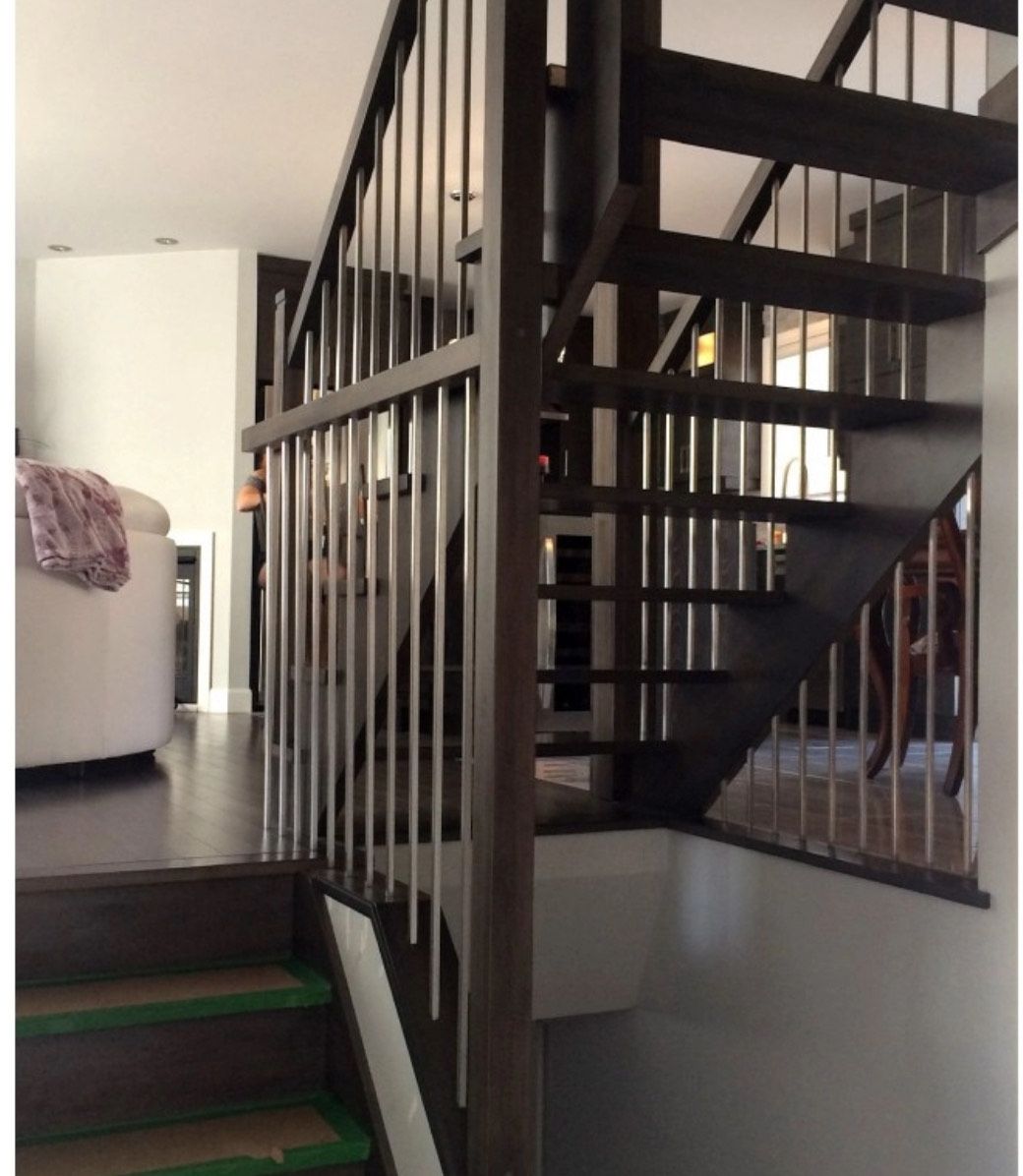 Dark wooden staircase with silver railings; leading to a lower level.