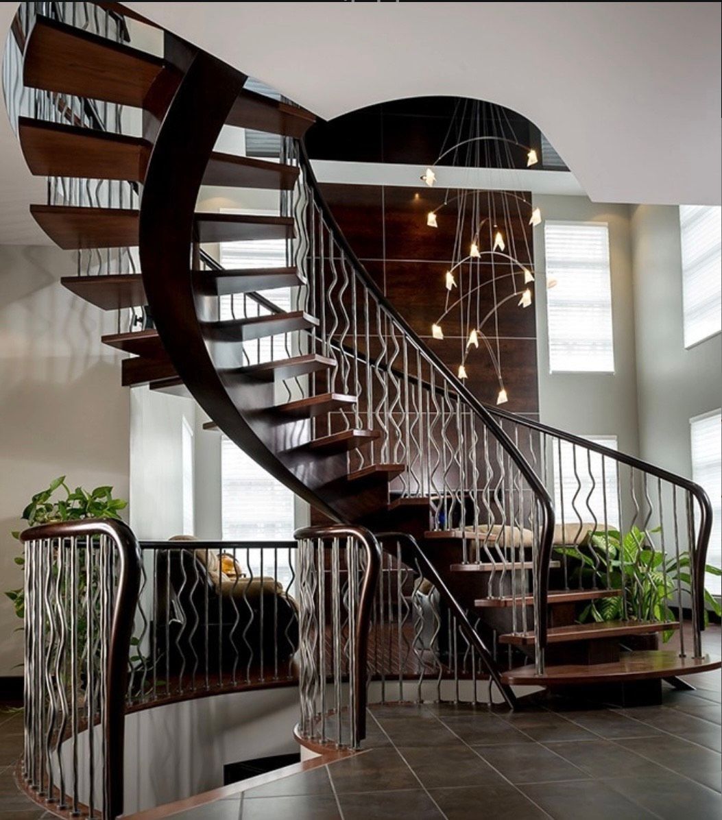 Elegant spiral staircase with wood steps and metal railings in a modern home.