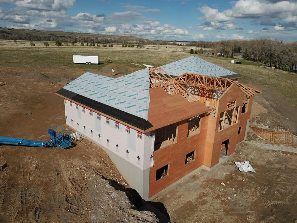 House under construction; one half has siding and roofing, the other half has exposed framing.