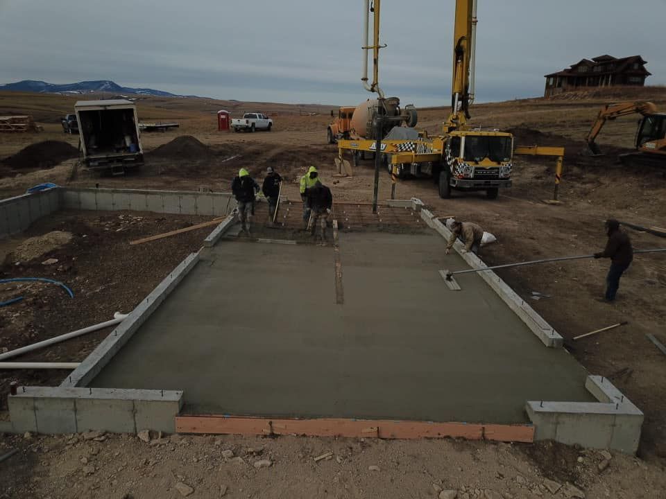 Construction crew pouring concrete foundation on a construction site, using a pump truck.