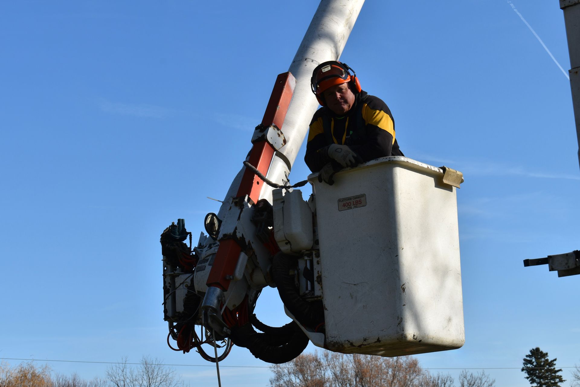 Daryl is sitting in a tree removal bucket on a crane.
