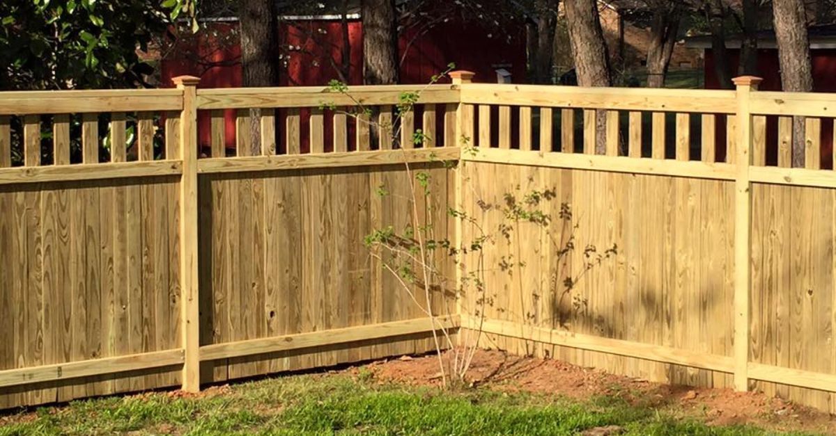 Wooden fence with a lattice top section in a backyard.