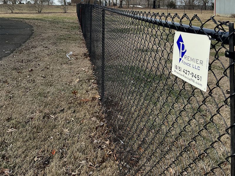 A chain link fence with a sign attached to it.