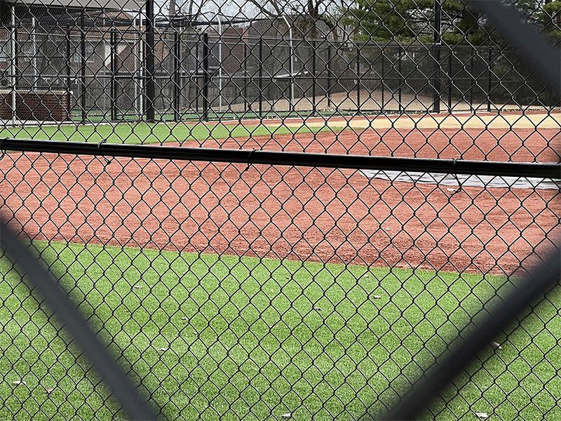 A baseball field is behind a chain link fence.