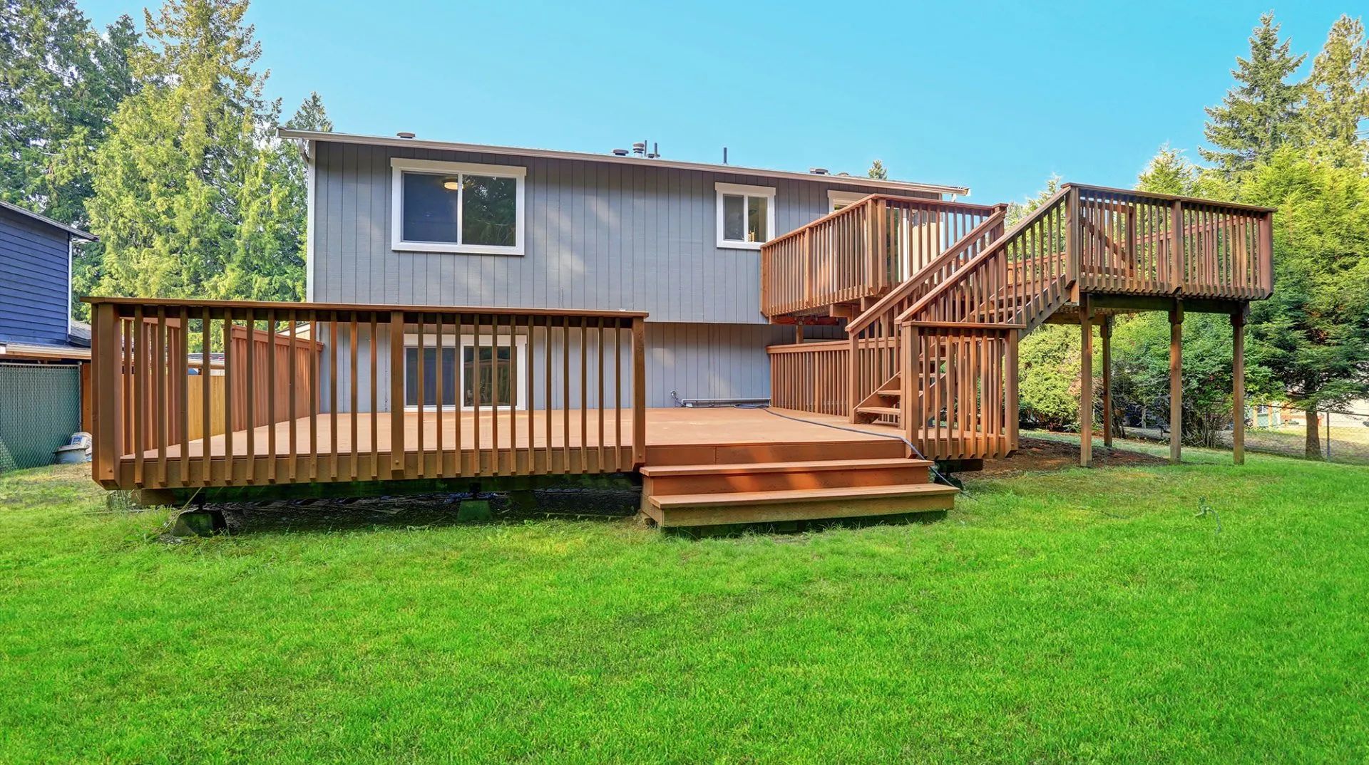 A wooden deck with stairs and a table and chairs on it.