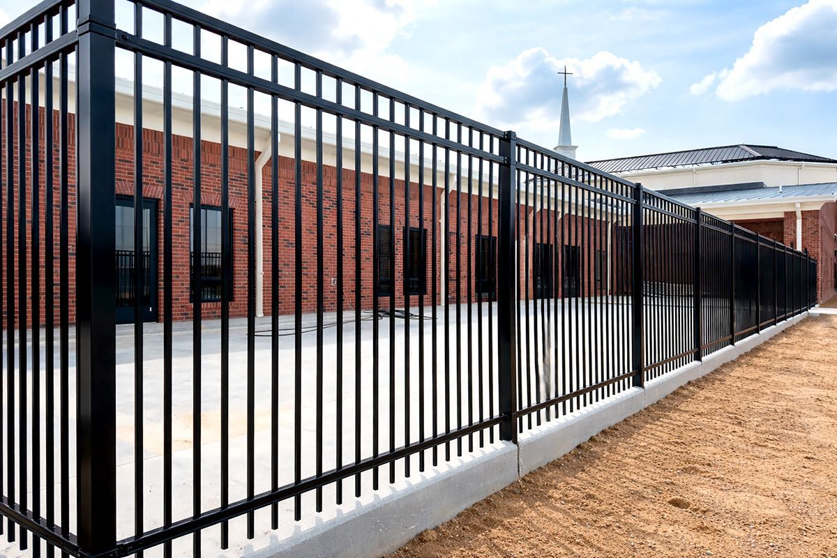 A black wrought iron fence on a white background.