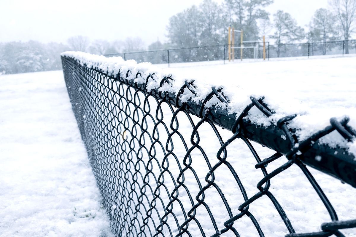 A chain link fence with a gate on a white background.
