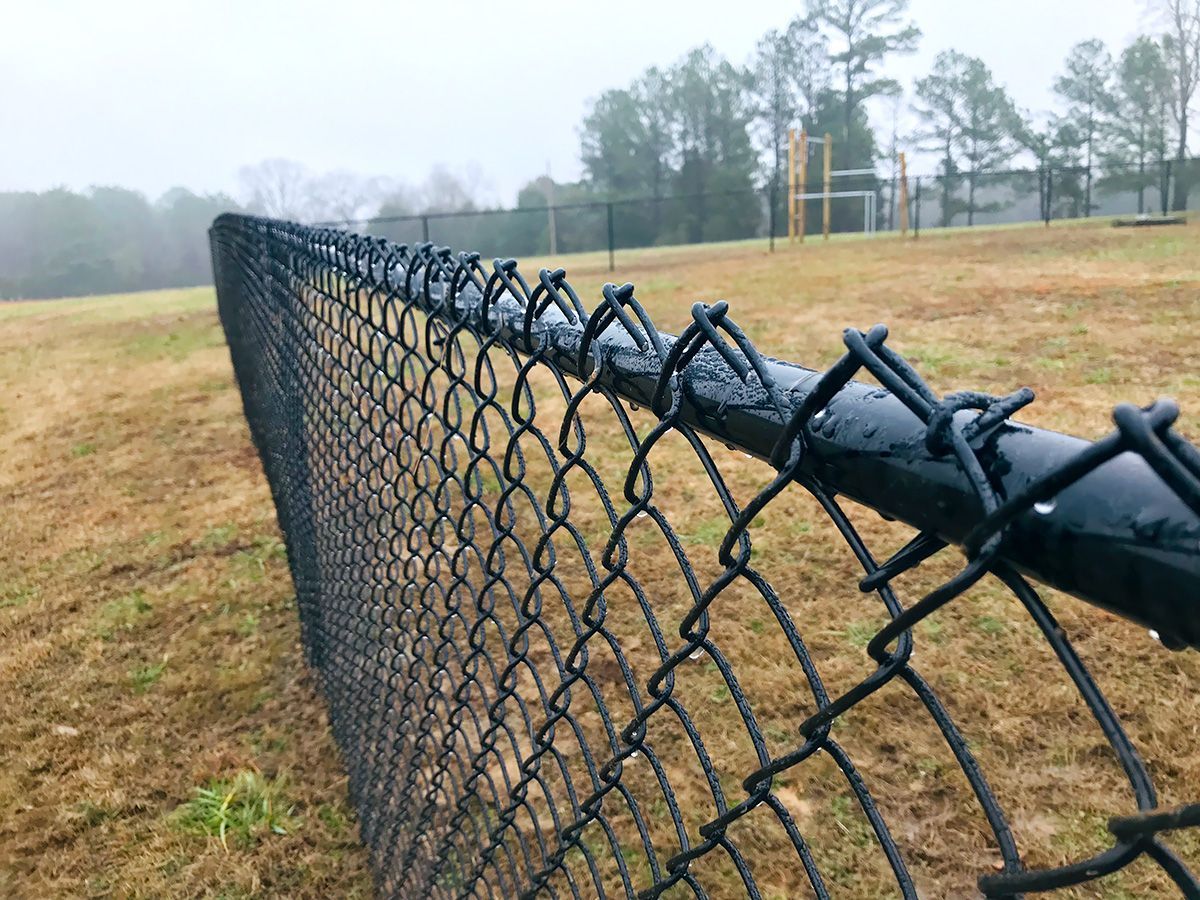 A chain link fence with barbed wire on top of it.
