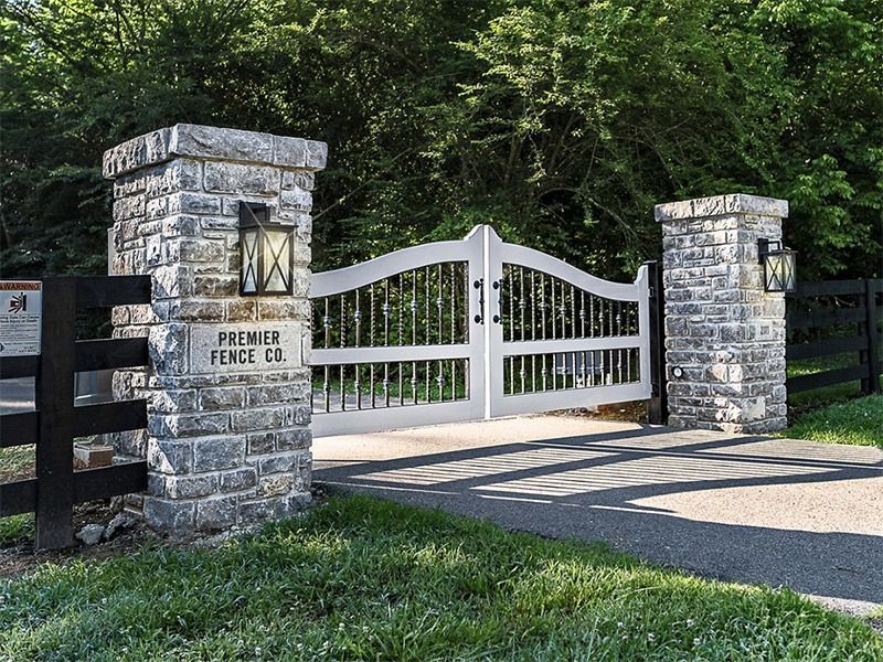 A white gate with a sign that says premier fence co.