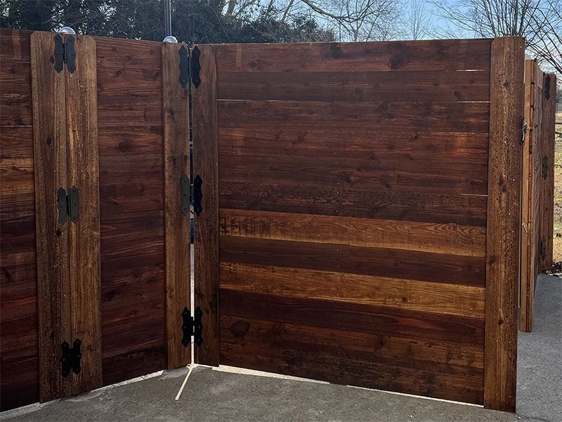 A wooden fence is sitting on top of a concrete driveway.
