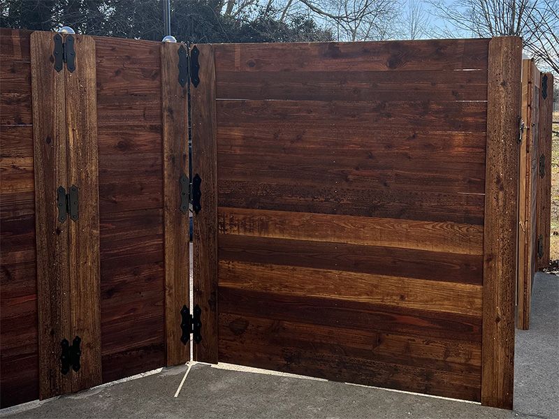 A wooden fence is sitting on top of a concrete driveway.