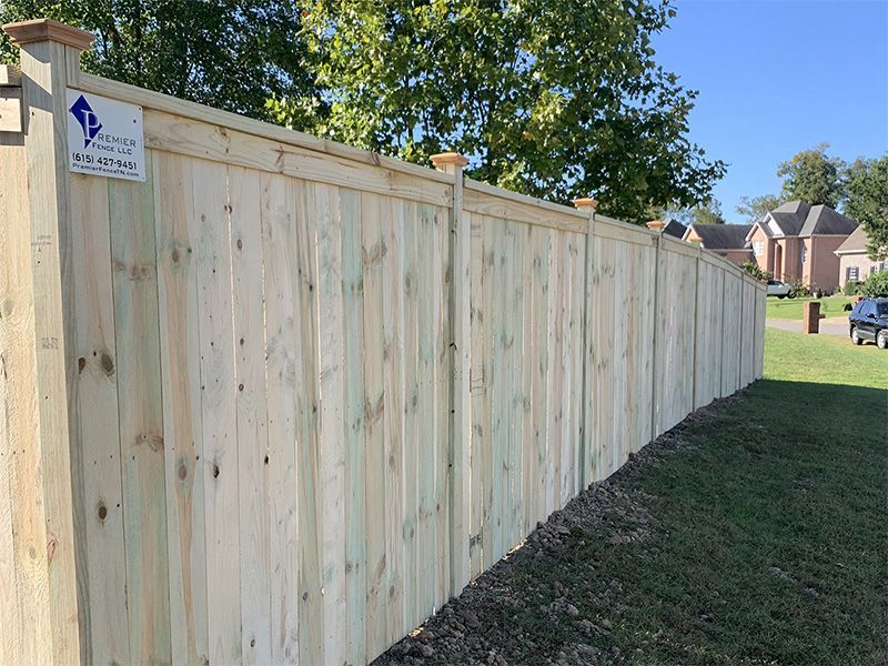 A wooden fence is sitting on top of a lush green field.