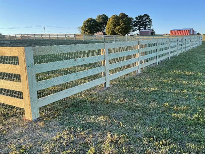 A wooden fence is sitting in the middle of a grassy field.