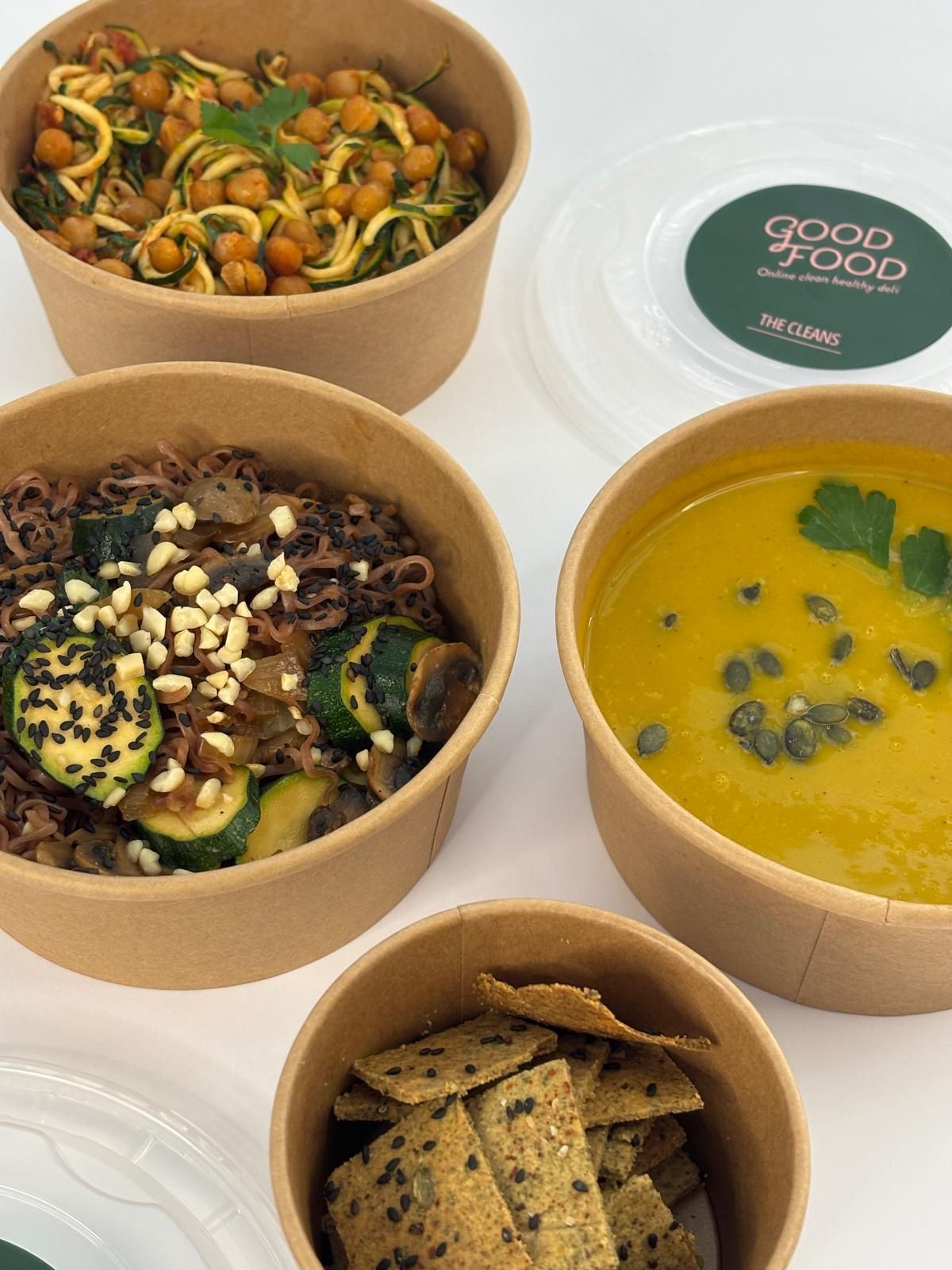 מגוון קערות אוכל כולל מרק וקרקרים מונחות על השולחן.