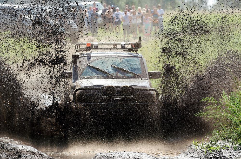 A 4wd Truck is Driving Through a Muddy Field — PT AUTO In Cardiff, NSW