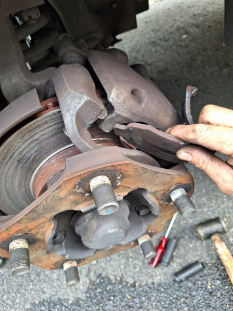 A Person is Fixing a Brake Pad on a Car — PT AUTO In Cardiff, NSW