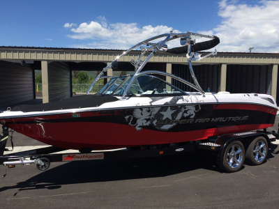 A red and white boat is parked in front of a building