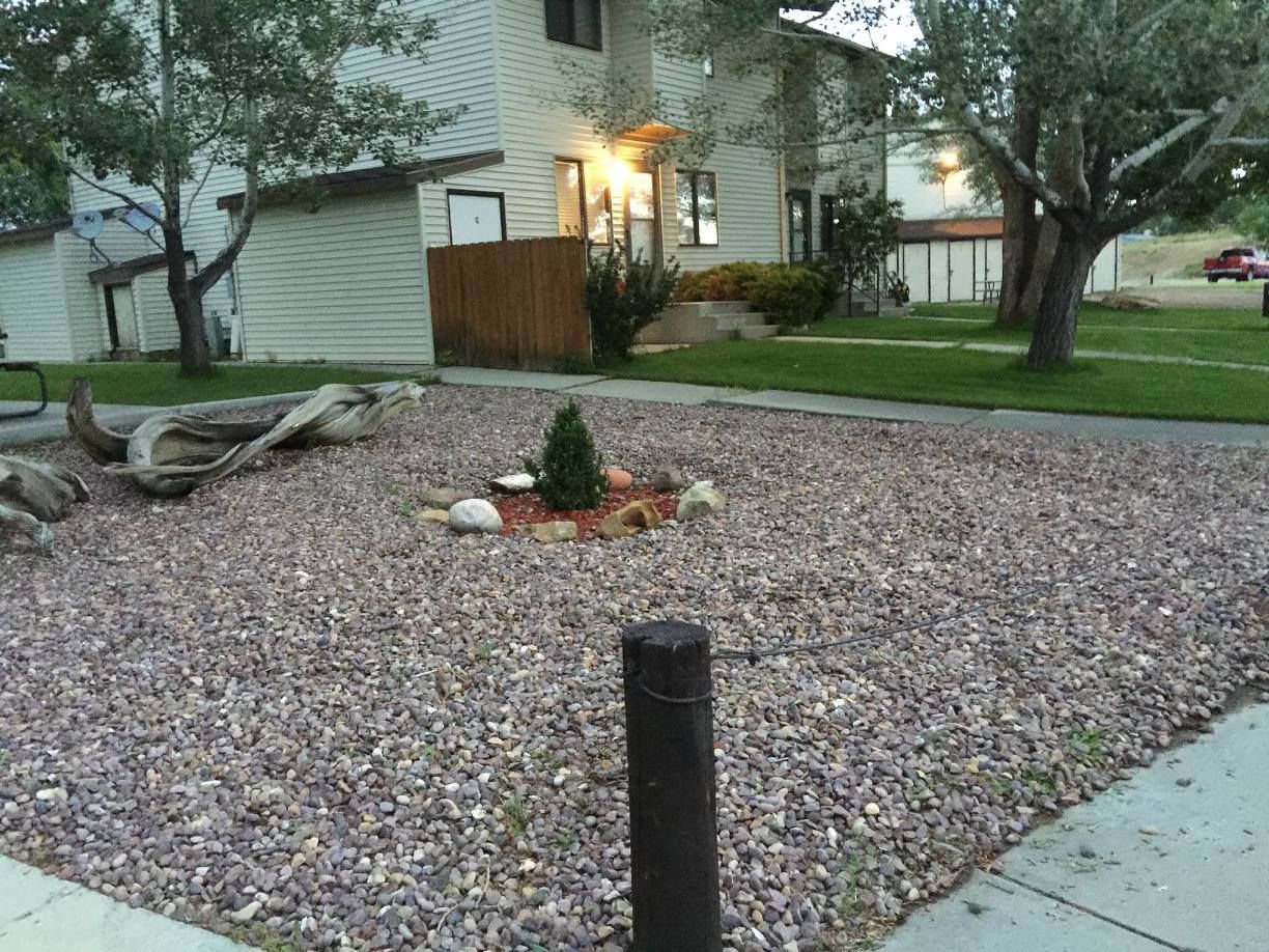 A house with a gravel yard in front of it
