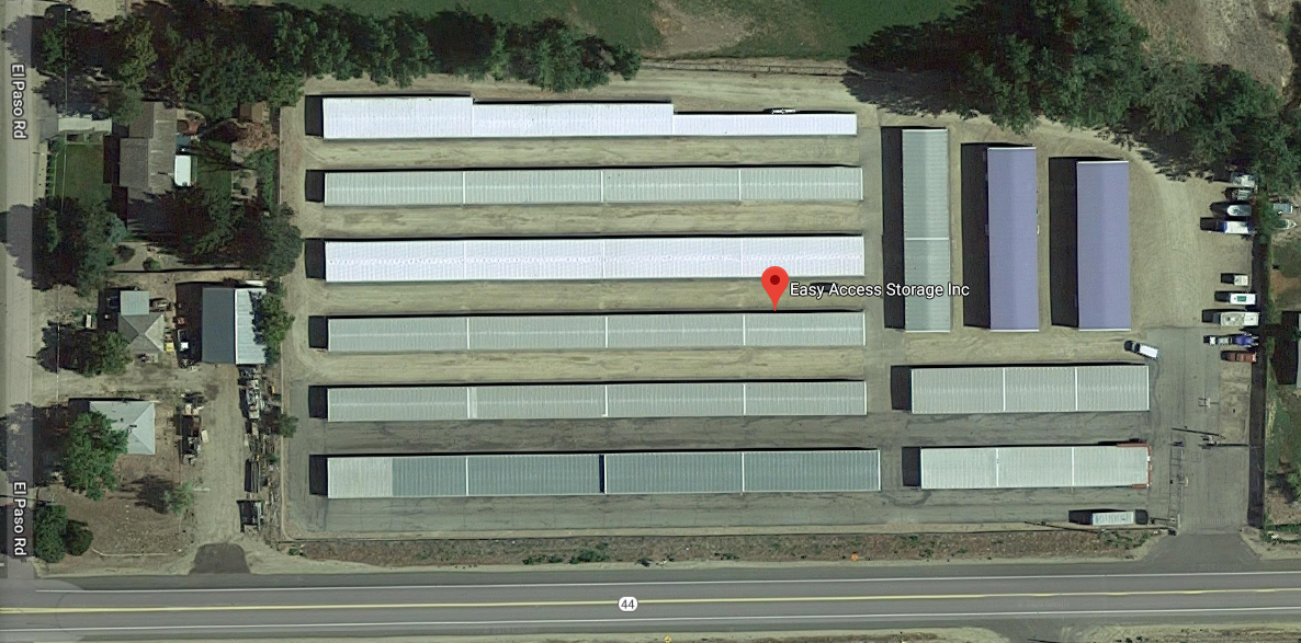 An aerial view of a parking lot with lots of buildings and trees.